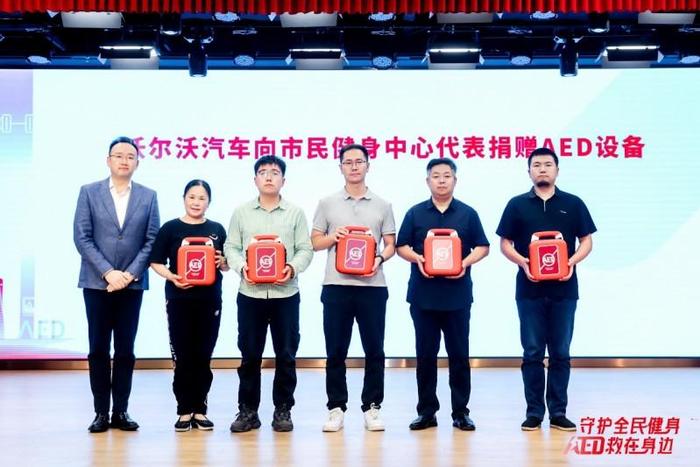（图：沃尔沃汽车代表向市民健身中心代表捐赠AED设备）